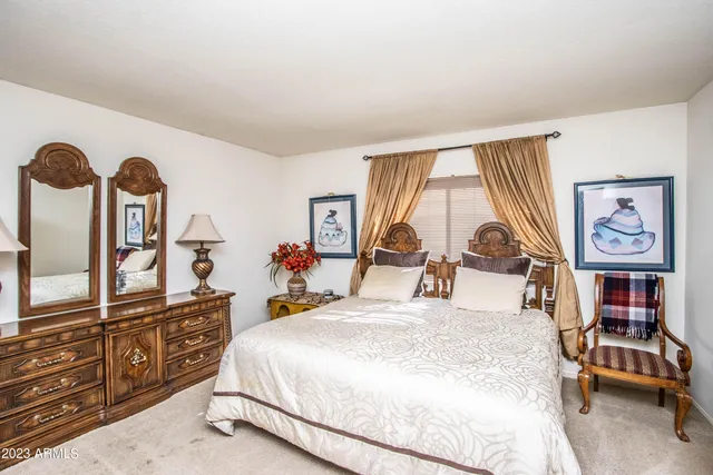 a bed room with a bed and dresser with mirror