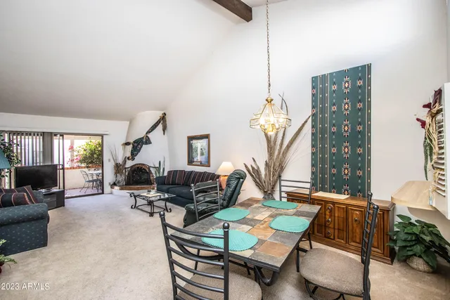 a living room with furniture a large window and a chandelier