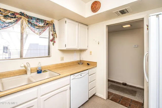 a kitchen with a sink cabinets and a window