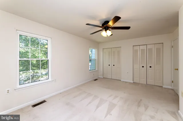 a view of a room with a ceiling fan and a window