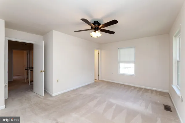 an empty room with a chandelier fan
