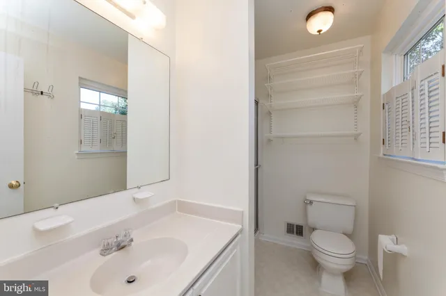 a bathroom with a toilet a sink and mirror