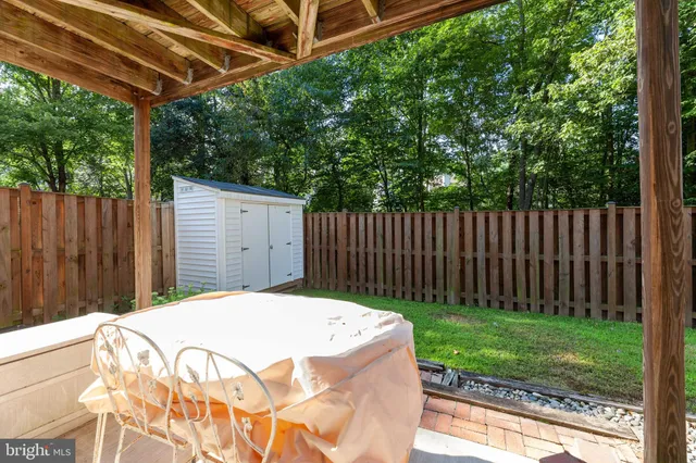 a backyard with wooden fence and large trees