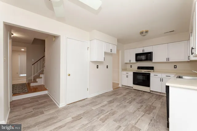 a kitchen with a refrigerator stove and white cabinets