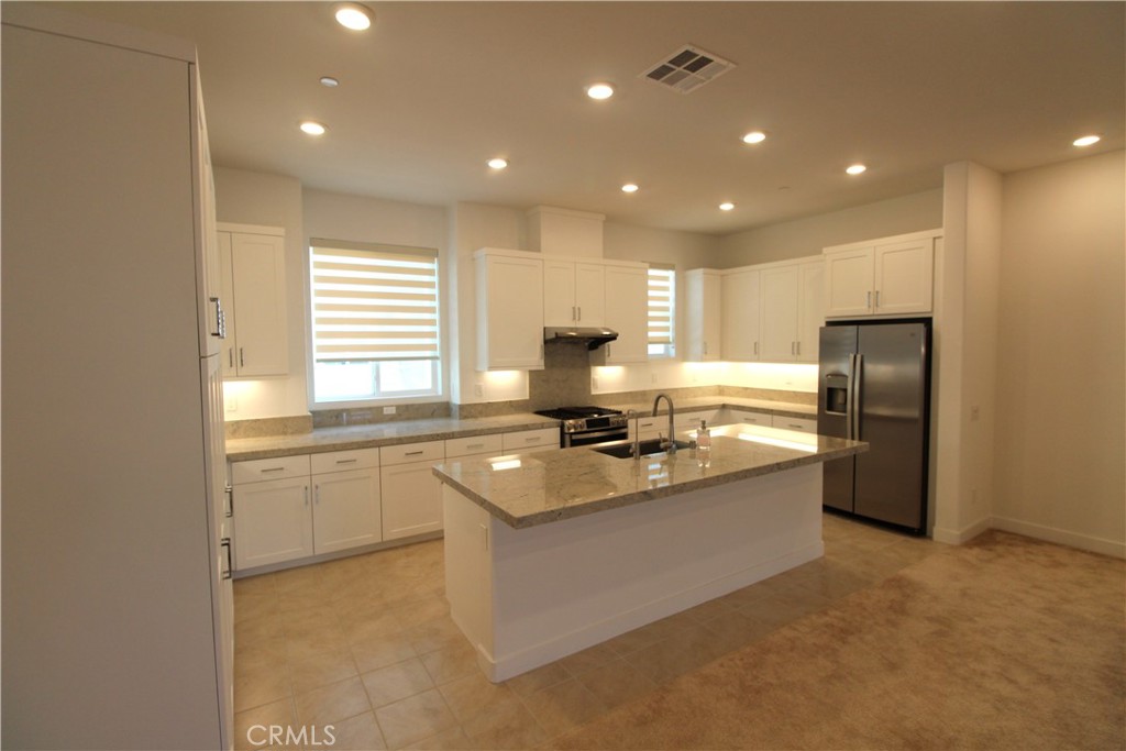 398 Merit Irvine, CA 92618 - Photo 11 of 25 a kitchen with stainless steel appliances granite countertop a sink stove and refrigerator