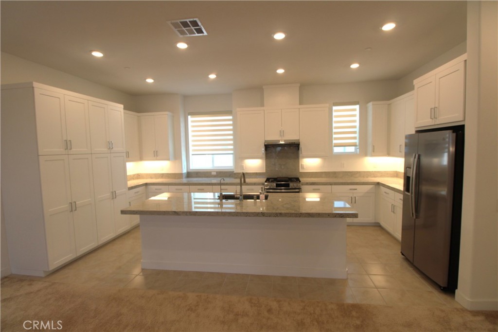 398 Merit Irvine, CA 92618 - Photo 10 of 25 a kitchen with stainless steel appliances granite countertop a sink a stove and a refrigerator