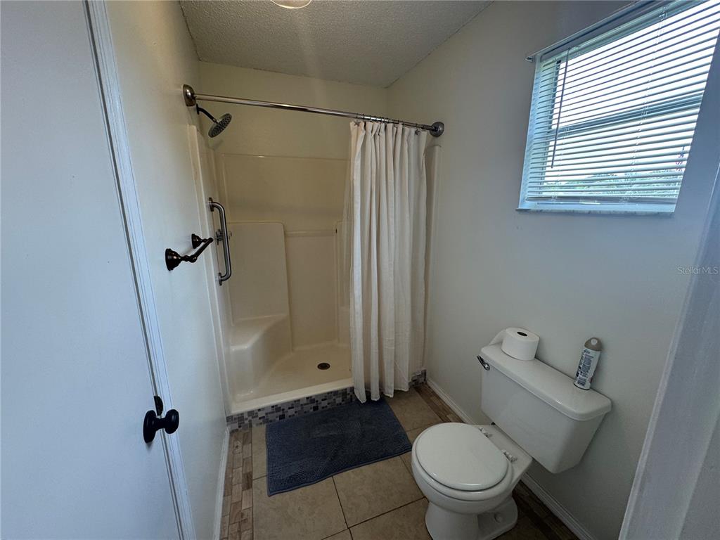 314 Juarez Way Lady Lake, FL 32159 - Photo 11 of 17 a bathroom with a granite countertop toilet sink and shower