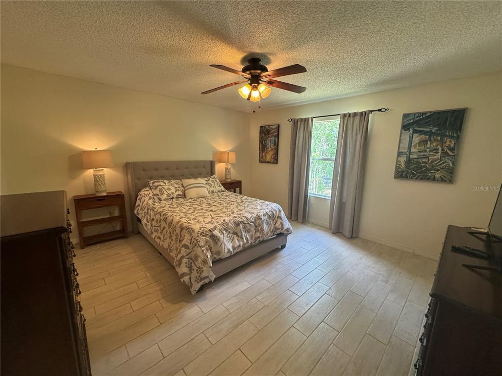 314 Juarez Way Lady Lake, FL 32159 - Photo 12 of 17 a bedroom with a bed and a chandelier
