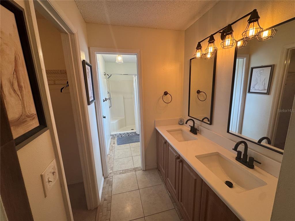 314 Juarez Way Lady Lake, FL 32159 - Photo 13 of 17 a bathroom with a sink a mirror a vanity and a shower