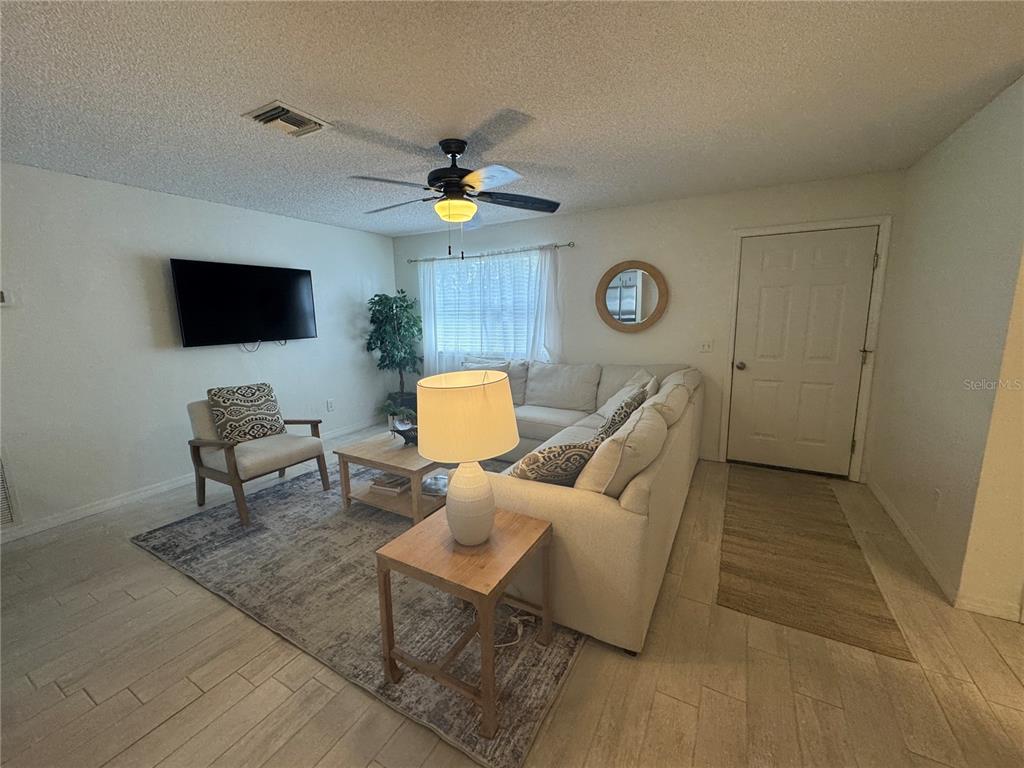 314 Juarez Way Lady Lake, FL 32159 - Photo 2 of 17 a living room with furniture and a flat screen tv