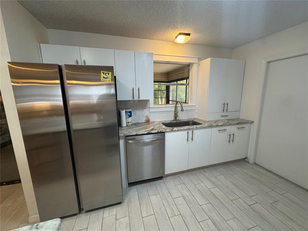 314 Juarez Way Lady Lake, FL 32159 - Photo 6 of 17 a kitchen with stainless steel appliances granite countertop a refrigerator a sink and a stove