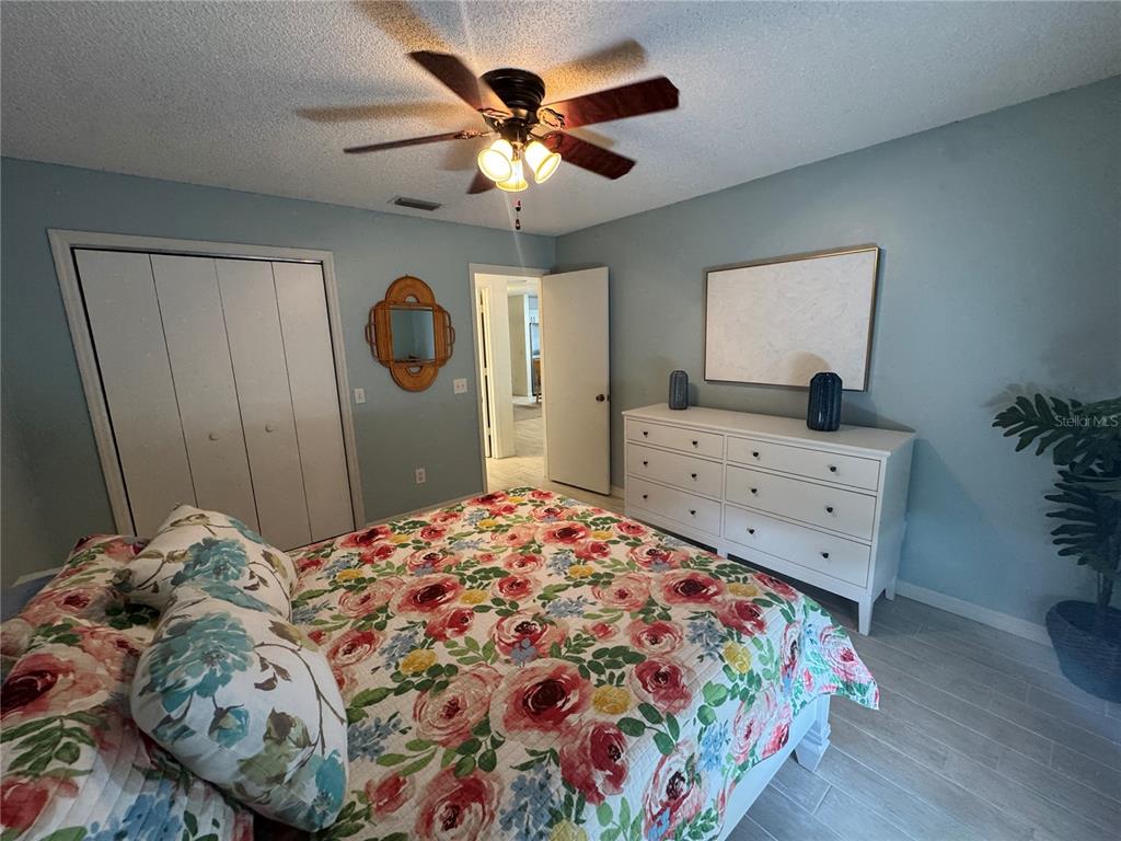 314 Juarez Way Lady Lake, FL 32159 - Photo 8 of 17 a bedroom with a bed and a chandelier