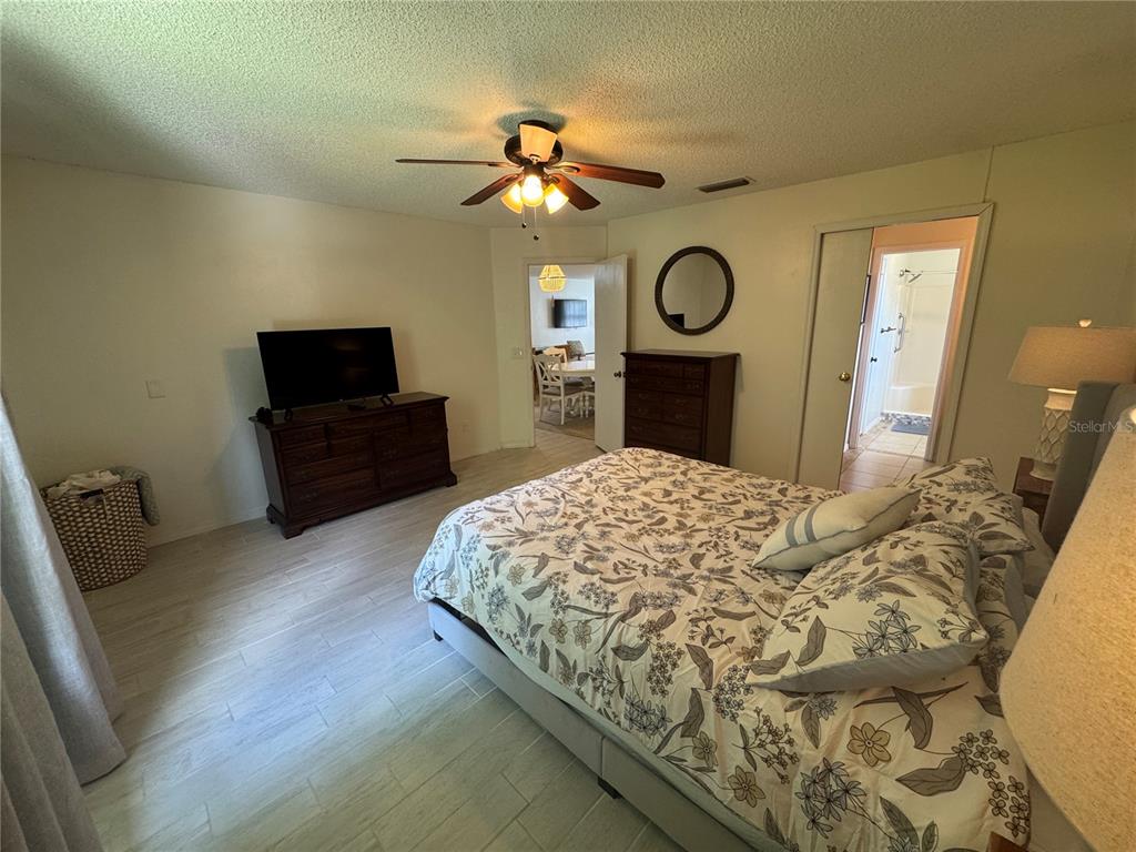 314 Juarez Way Lady Lake, FL 32159 - Photo 10 of 17 a bedroom with a bed and a flat tv screen on dresser