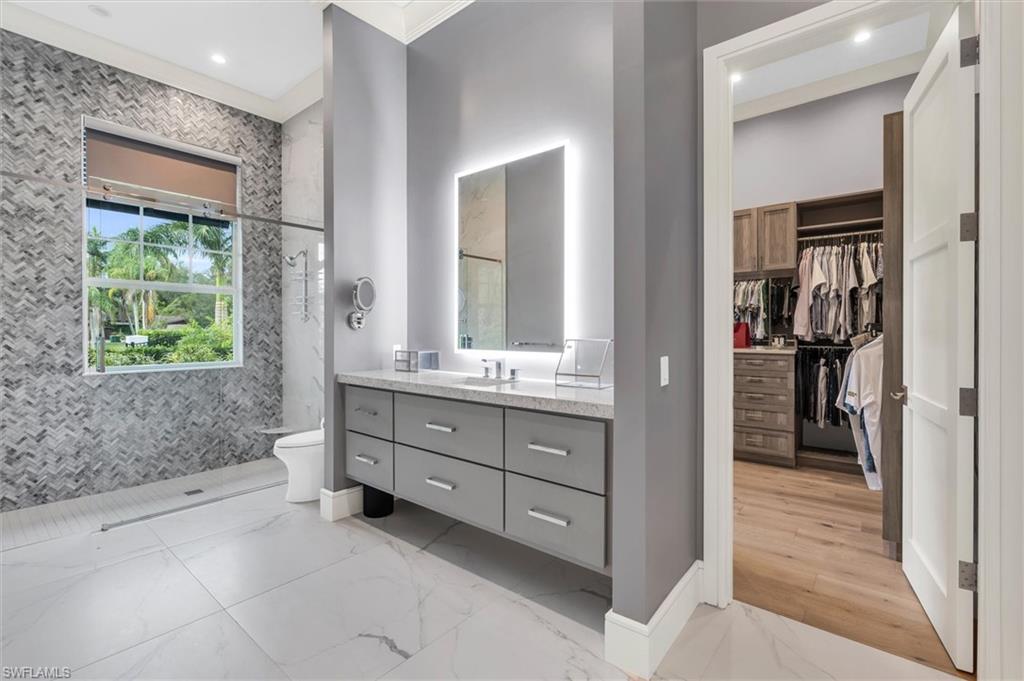830 Cassena Road Naples, FL 34108 - Photo 12 of 41 a bathroom with a sink a mirror and a bathtub