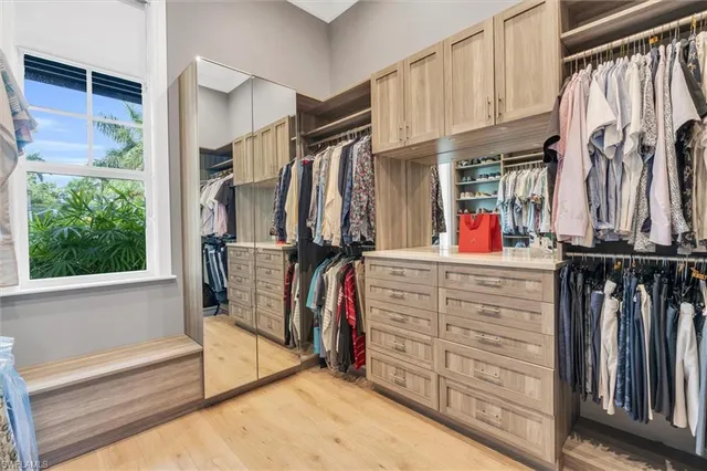 a view of walk in closet with clothes and shoes