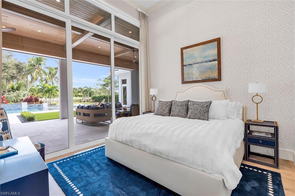 830 Cassena Road Naples, FL 34108 - Photo 14 of 41 a large bedroom with a bed and wooden floor