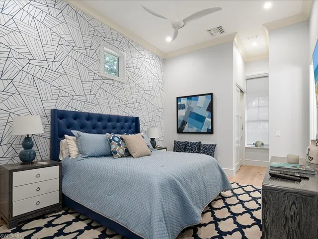 a bedroom with a bed and a lamp on dresser