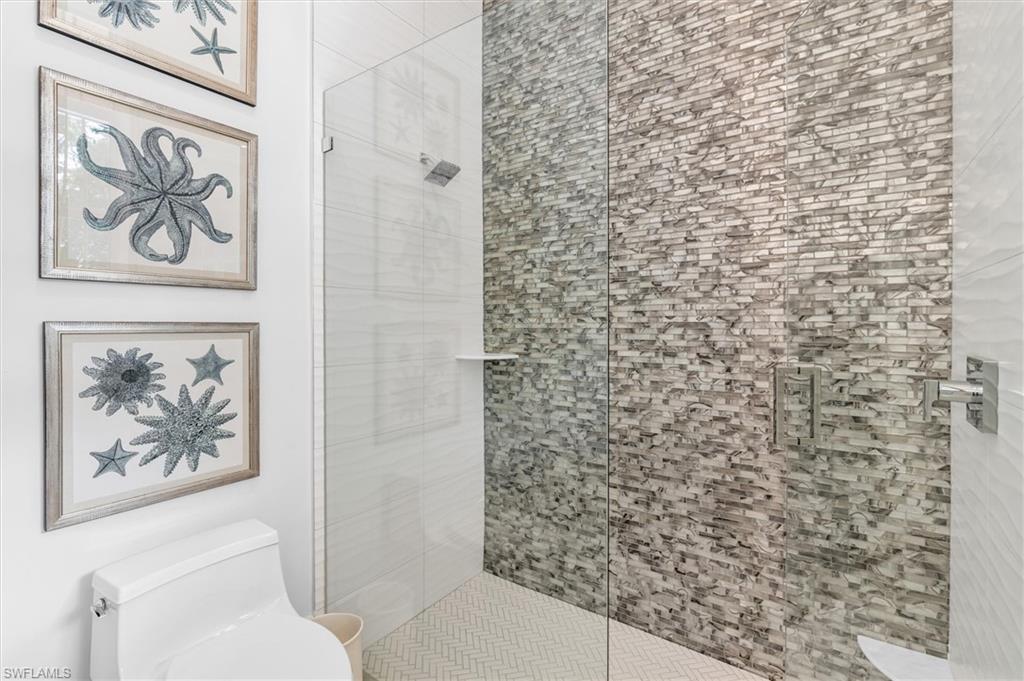 830 Cassena Road Naples, FL 34108 - Photo 18 of 41 a bathroom with a toilet and a shower curtain