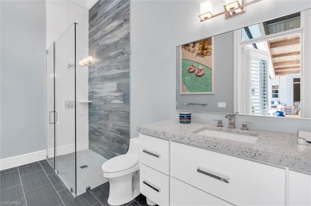 830 Cassena Road Naples, FL 34108 - Photo 27 of 41 a bathroom with a granite countertop sink toilet and shower