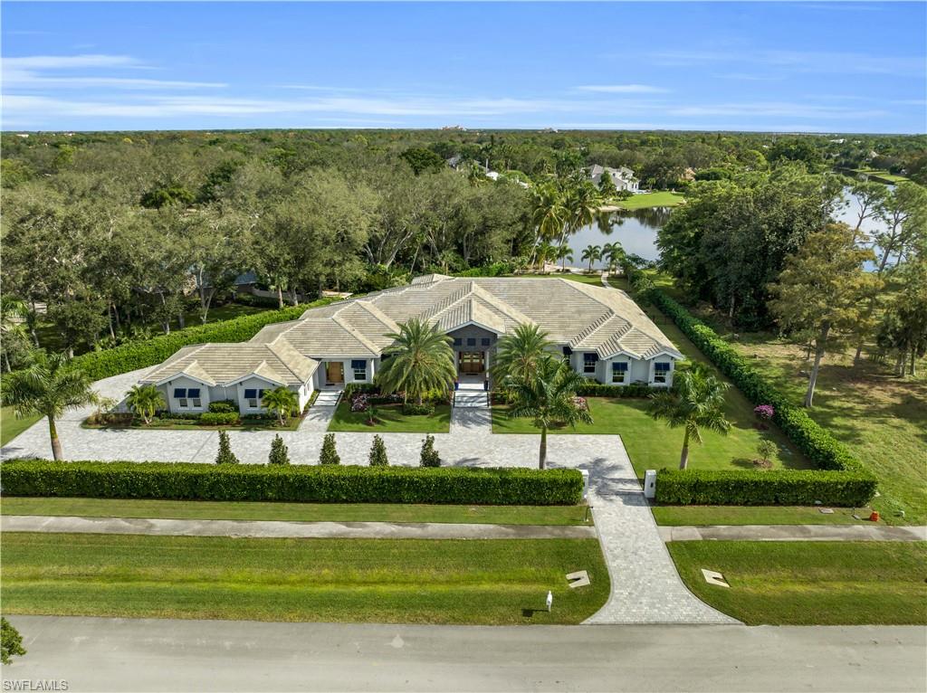 830 Cassena Road Naples, FL 34108 - Photo 38 of 41 a view of a big yard with table and chairs under an umbrella