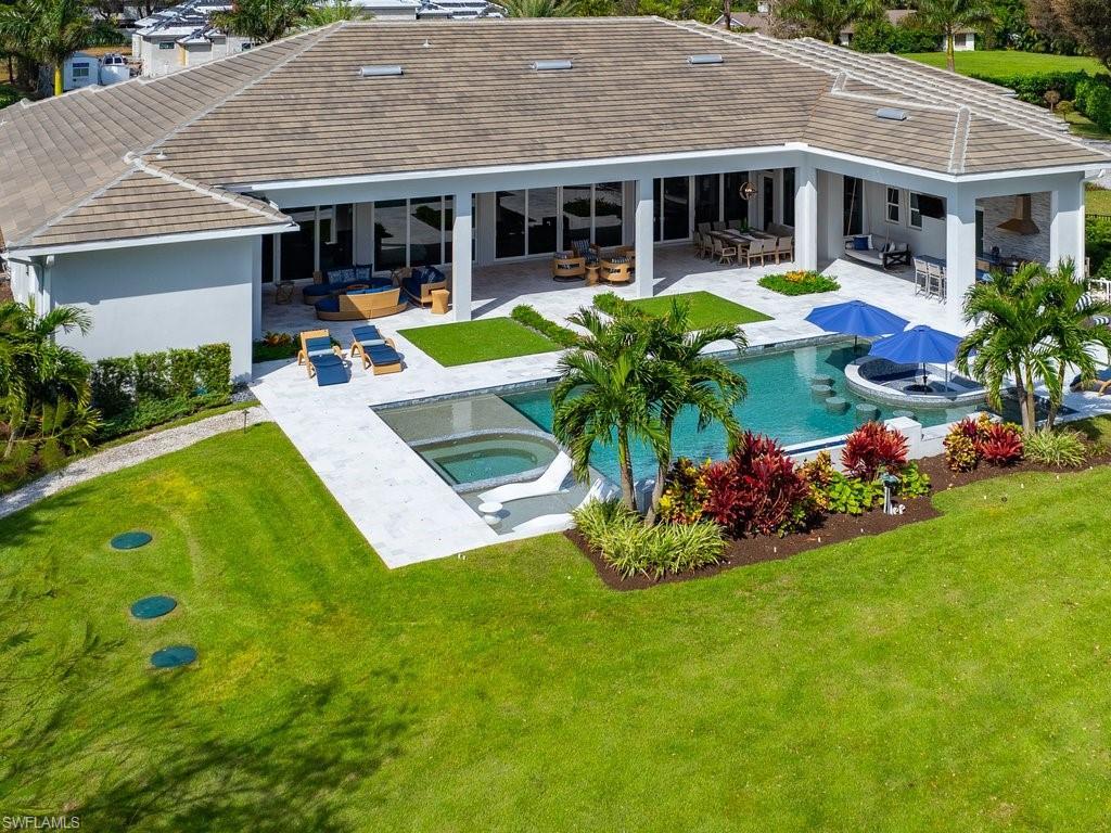 830 Cassena Road Naples, FL 34108 - Photo 40 of 41 a view of a house with swimming pool and a chairs