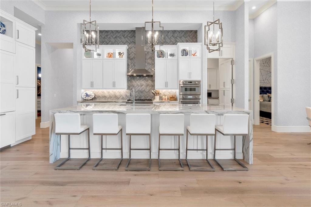 830 Cassena Road Naples, FL 34108 - Photo 4 of 41 a kitchen with stainless steel appliances kitchen island granite countertop a dining table chairs and granite counter tops