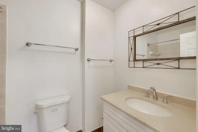 a bathroom with a granite countertop sink toilet and a mirror