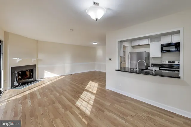 a view of a livingroom with a fireplace a sink and a window