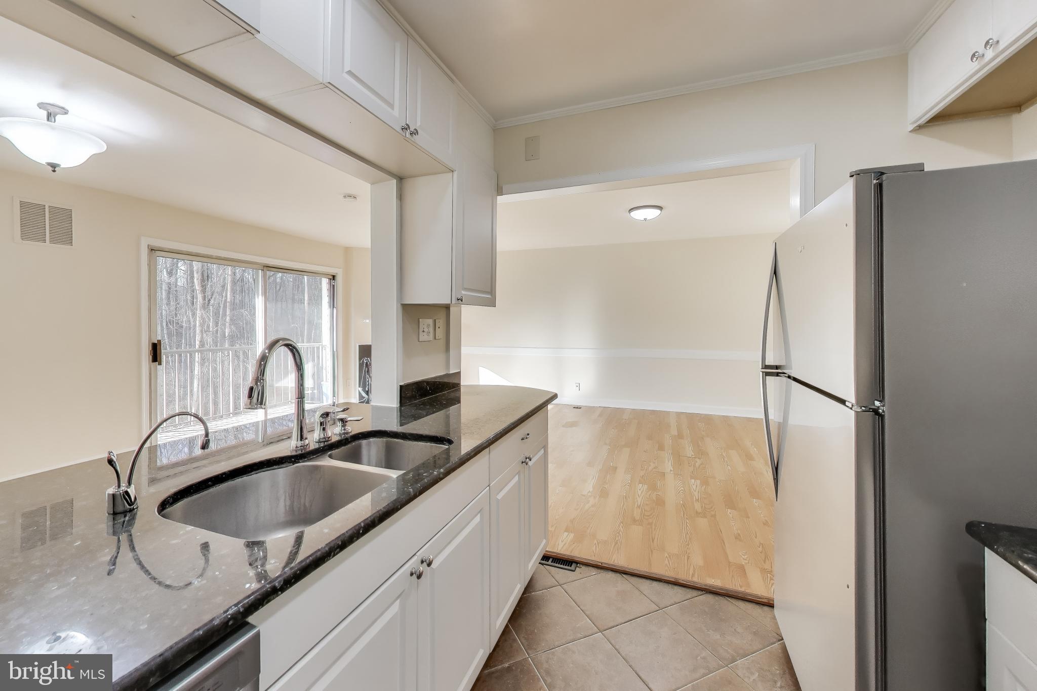 10408 Parthenon Court, Unit 10408 Bethesda, MD 20817 - Photo 4 of 34 a kitchen with granite countertop a sink refrigerator and cabinets