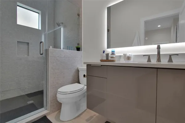 a bathroom with a sink a toilet and a mirror