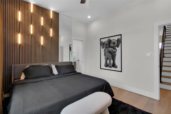 a bedroom with a bed and painting on the wall