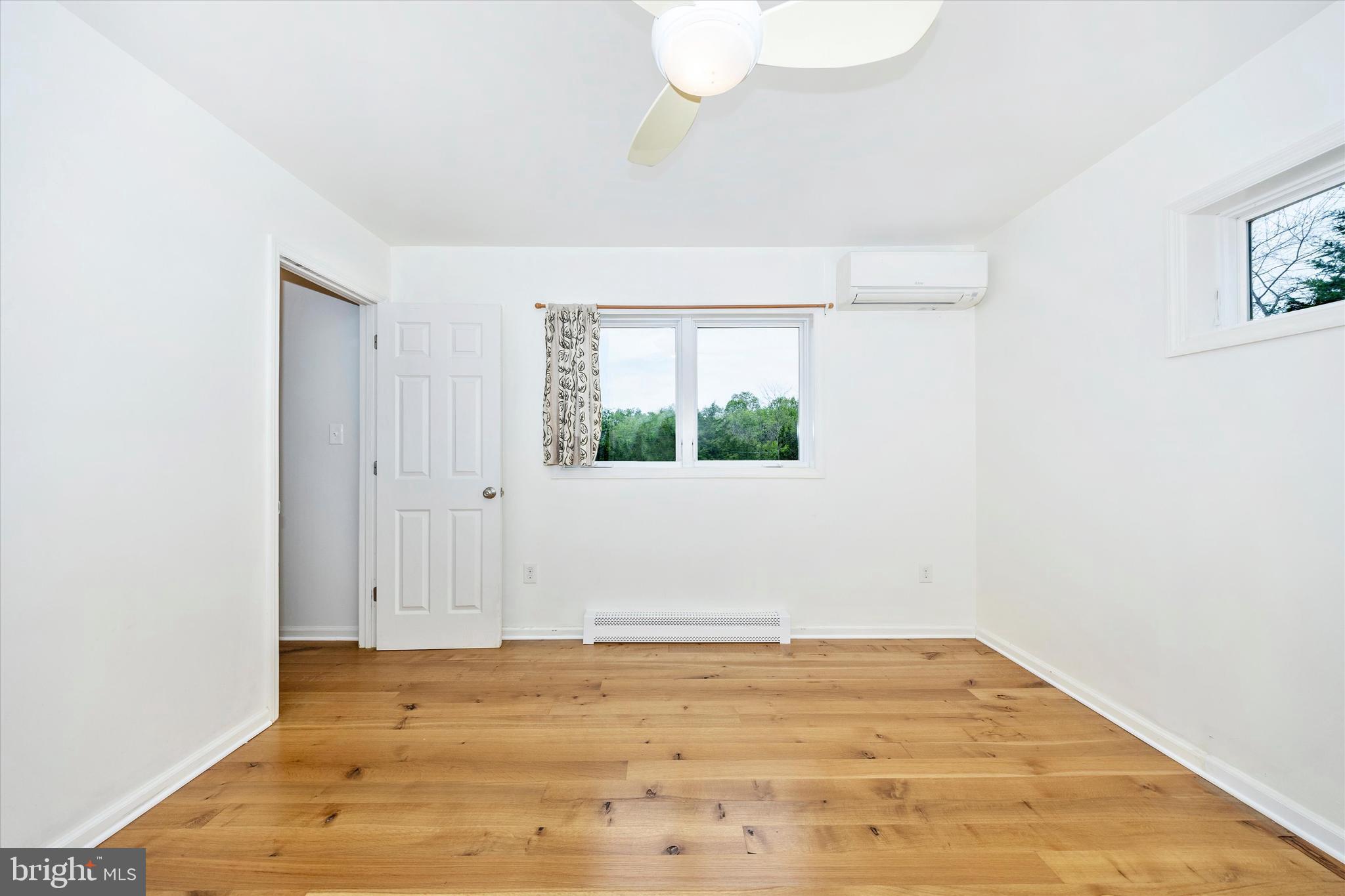 9930 Woodsboro Road Frederick, MD 21701 - Photo 23 of 58 an empty room with wooden floor and windows