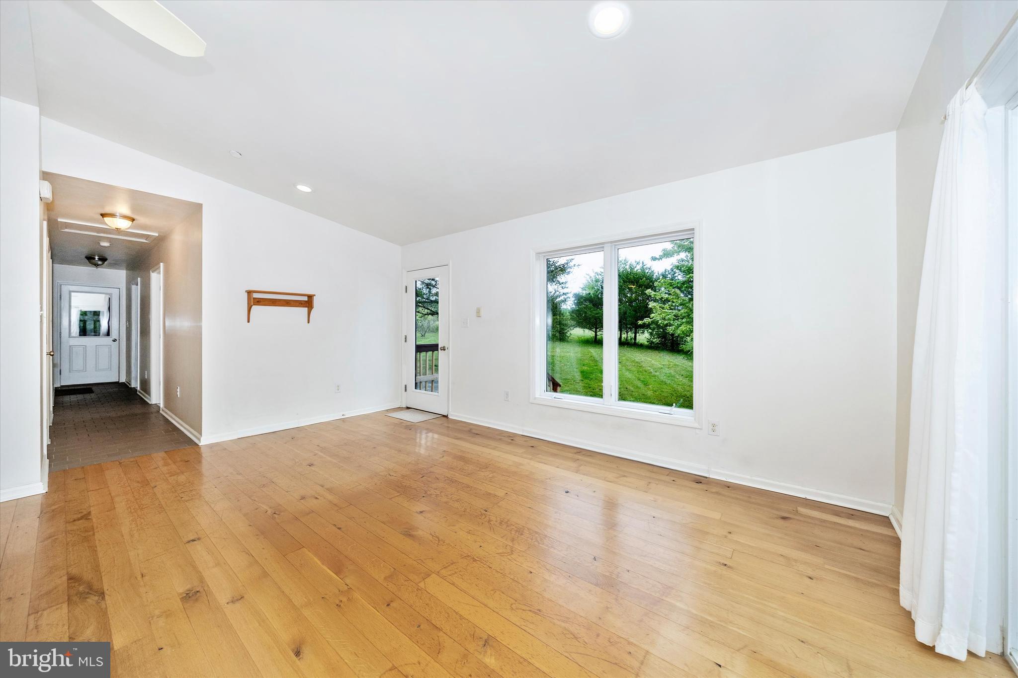 9930 Woodsboro Road Frederick, MD 21701 - Photo 6 of 58 an empty room with wooden floor and windows