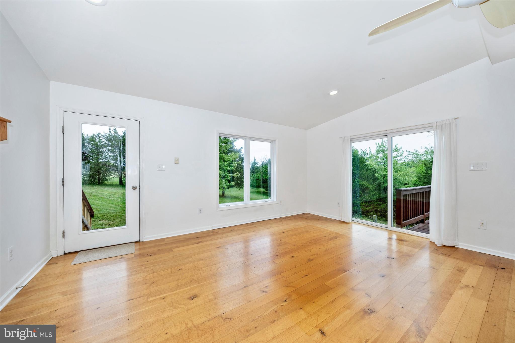 9930 Woodsboro Road Frederick, MD 21701 - Photo 8 of 58 a view of an empty room with wooden floor and a window