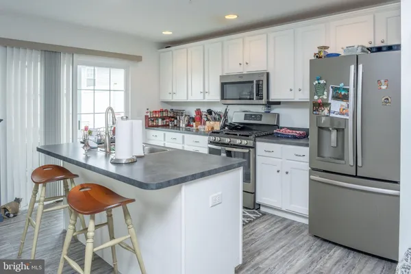a kitchen with stainless steel appliances granite countertop a stove a refrigerator and a microwave