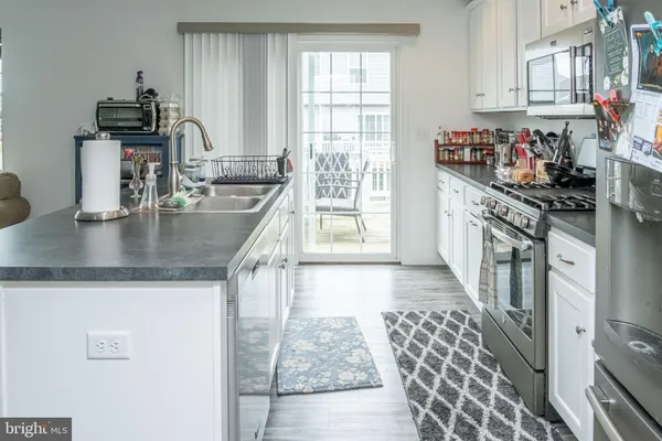 a kitchen with stainless steel appliances granite countertop a sink stove and cabinets
