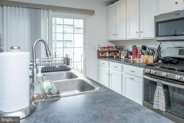 a kitchen with granite countertop a sink stainless steel appliances and cabinets