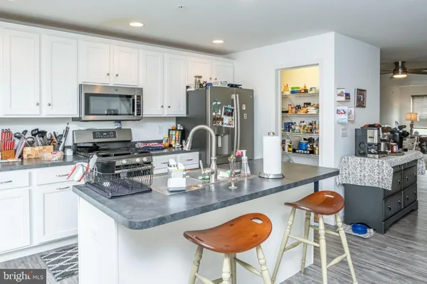 a kitchen with granite countertop a table chairs stove and cabinets