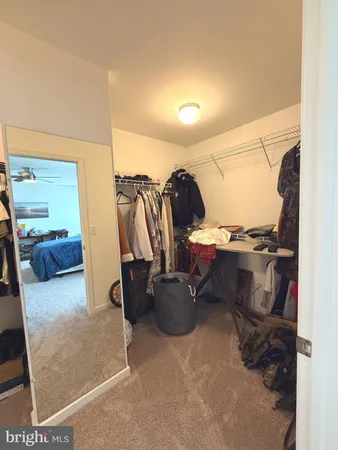 a view of walk in closet with clothes and shoes