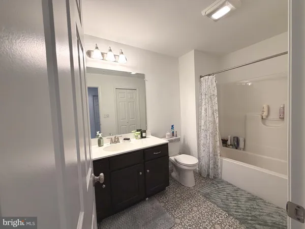 a bathroom with a double vanity sink toilet mirror and bathtub
