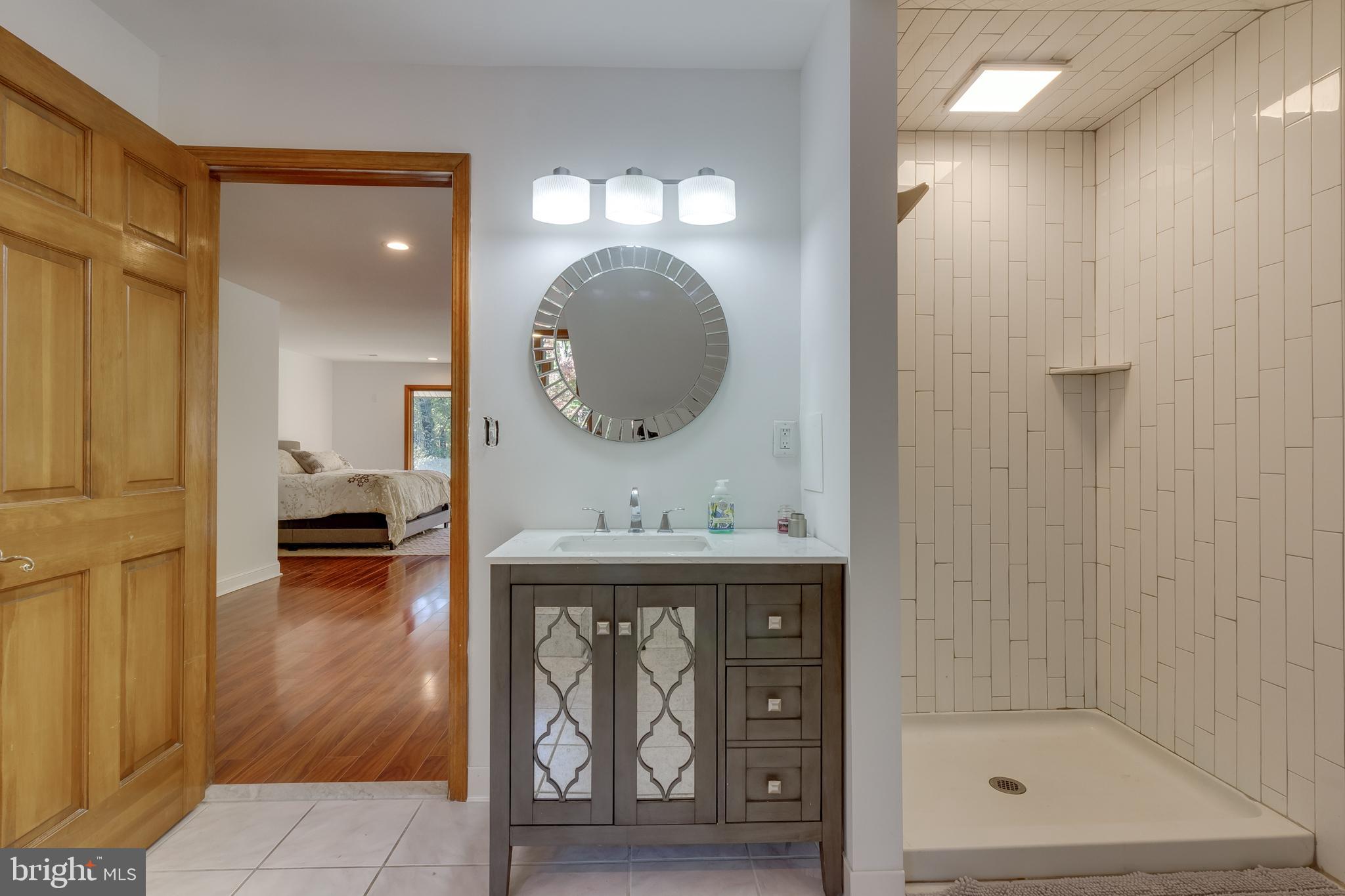 83 Grassy Lake Road Shamong, NJ 08088 - Photo 27 of 48 a bathroom with a sink a mirror and a shower