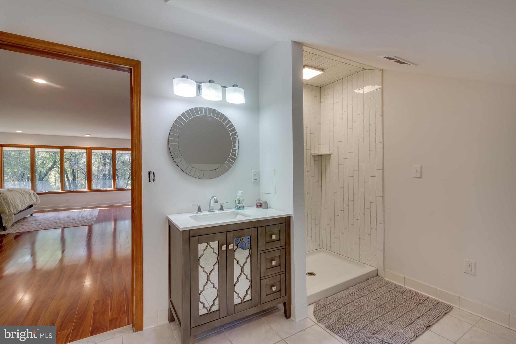 83 Grassy Lake Road Shamong, NJ 08088 - Photo 29 of 48 a bathroom with a sink a mirror and a shower