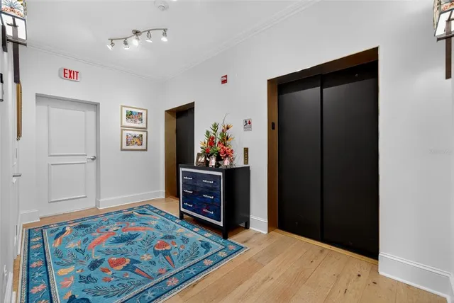 a view of a hallway with wooden floor and staircase