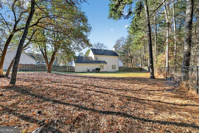 a view of a yard with plants and trees