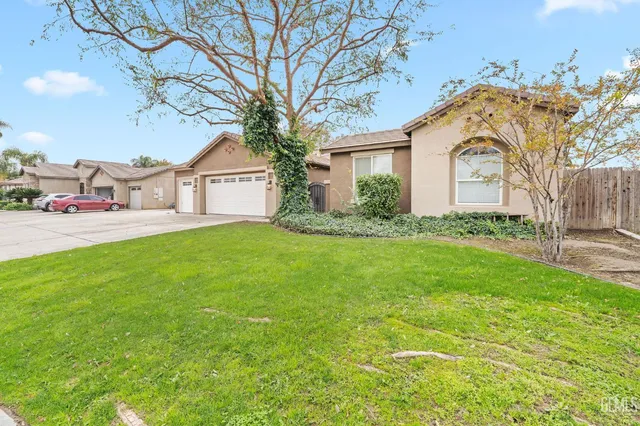 a front view of a house with a garden and trees