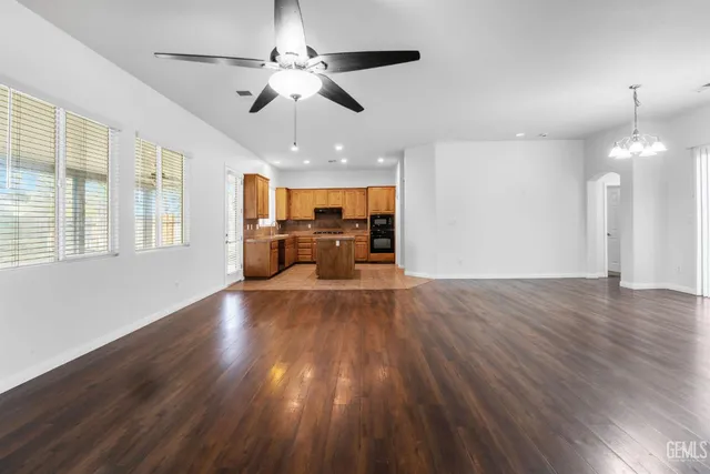 a view of an empty room with wooden floor and windows