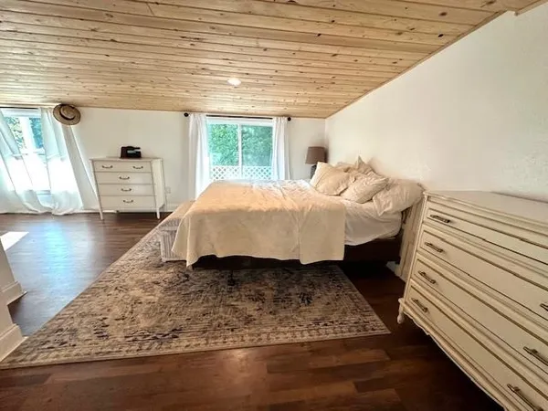 a bed sitting in a spacious bedroom next to a window