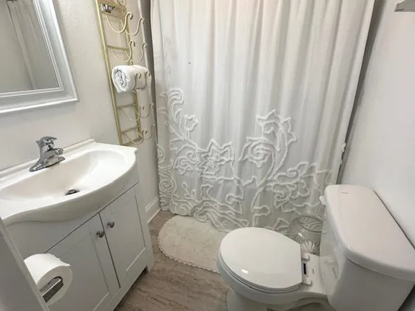 a bathroom with a toilet sink and shower curtain