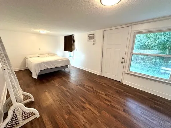 a bedroom with a bed and wooden floor