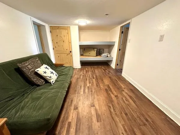 a bedroom with a bed and a wooden floor